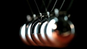 stock-footage-close-up-of-newton-s-cradle-desk-toy-pendulum-being-activated-black-background